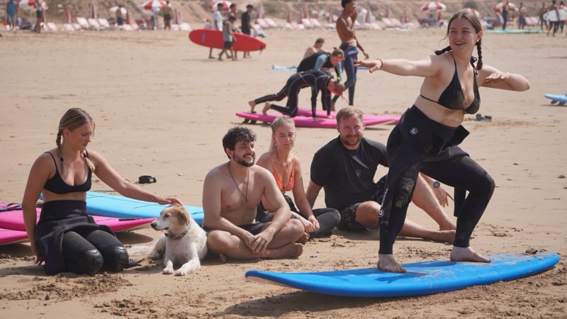Student practising the pop-up on the sand while the group watches