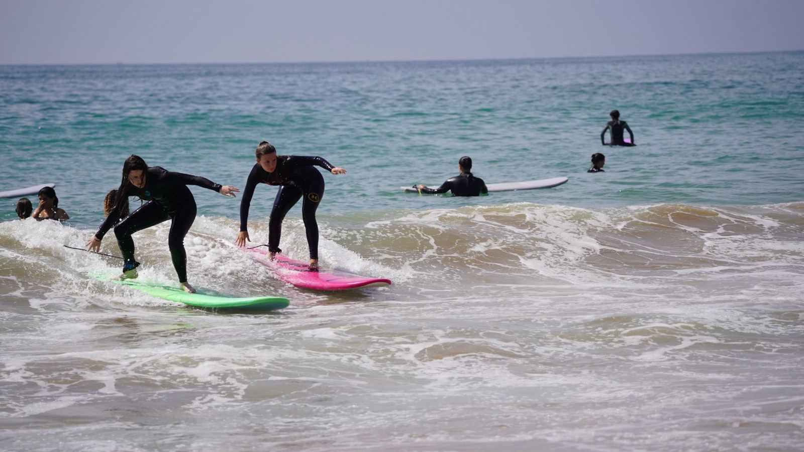 Deux débutants qui surfent la mousse côte à côte sur des planches souples