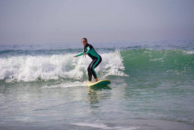 Surf instructor teaching a beginner during a lesson in Taghazout, Morocco
