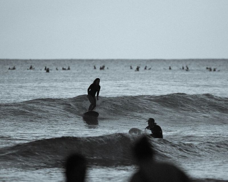 Surfers waiting for waves in the warm water lineup at Taghazout, Morocco