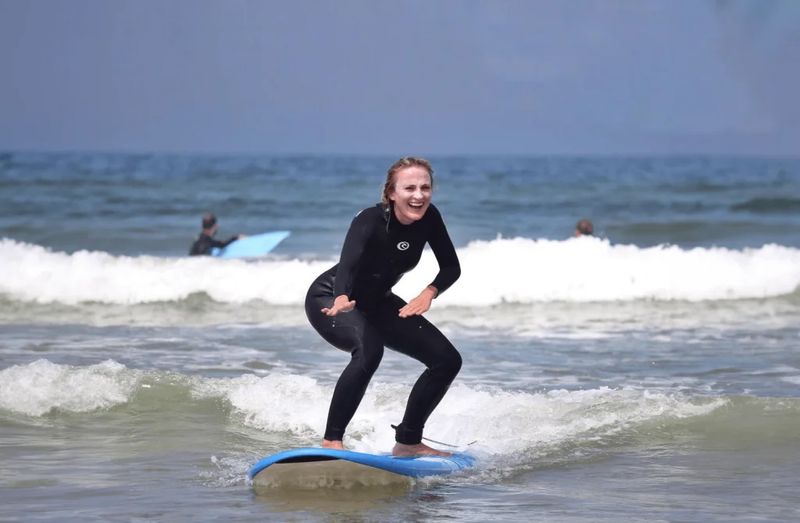 Surfer riding a wave on a rented board in Taghazout, Morocco