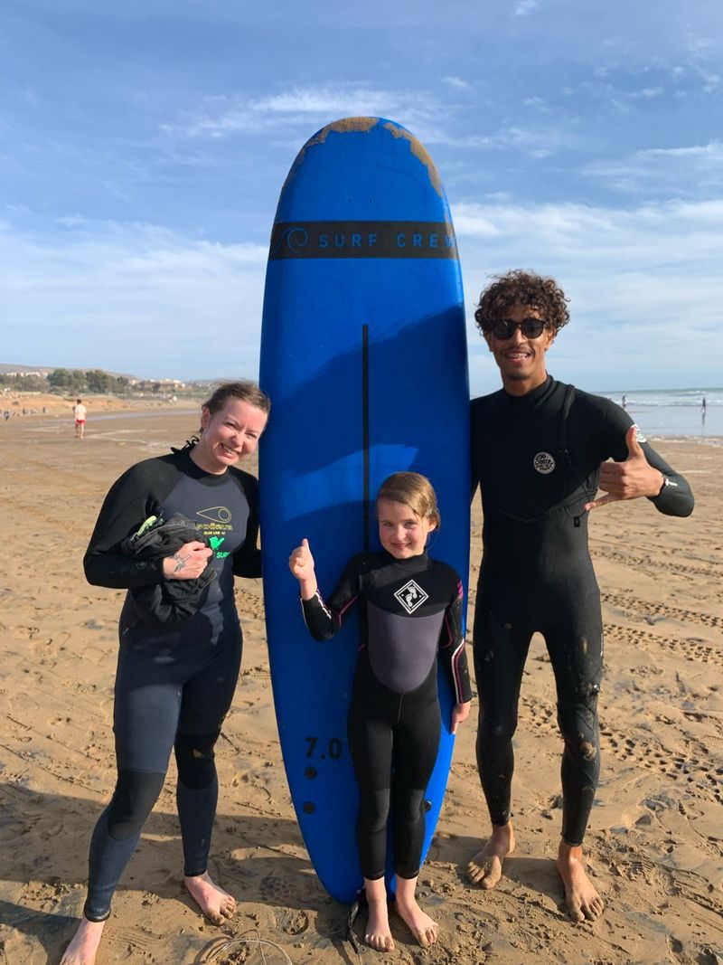 A family learning to surf together during a group surf lesson in Taghazout, Morocco