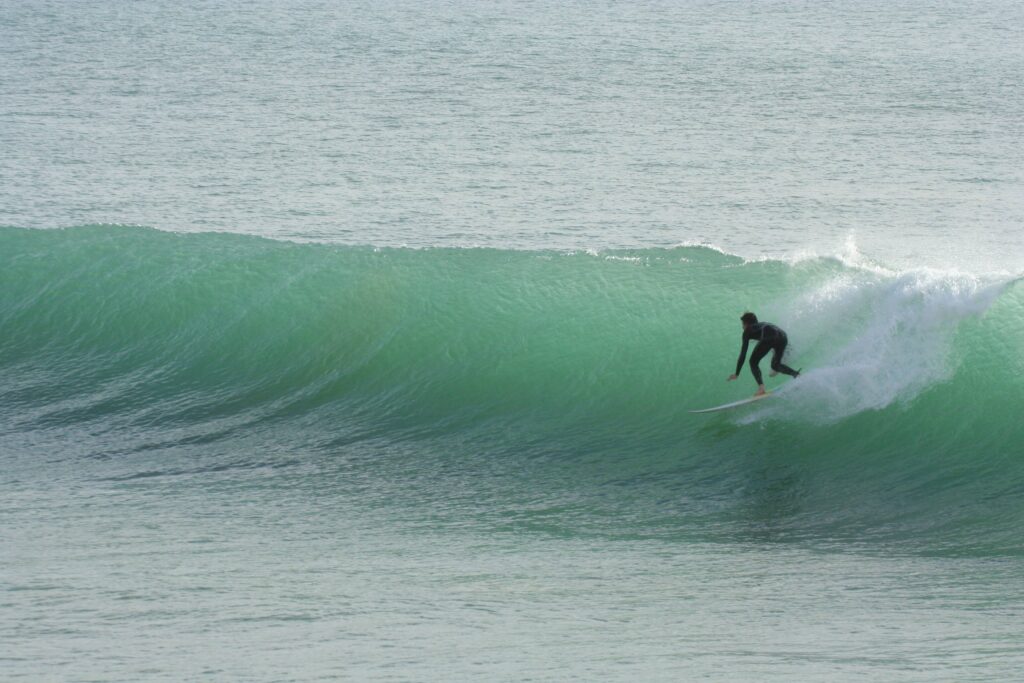Surfer carving turn at Killer Point reef break, Taghazout Morocco