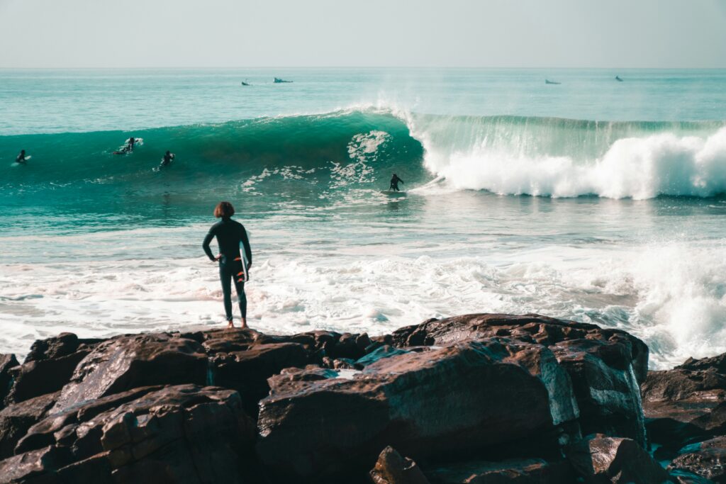 Surfers riding a powerful wave at Anchor Point in Taghazout, Morocco, one of the most famous right-hand point breaks and best surf spots in the country.
